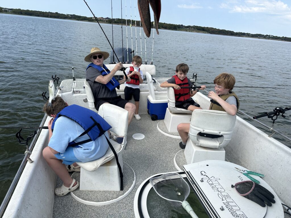 Family Fishing Trip On A Boat With Fishing Rods And Gear.